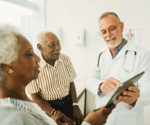 A doctor shows a chart to a senior couple